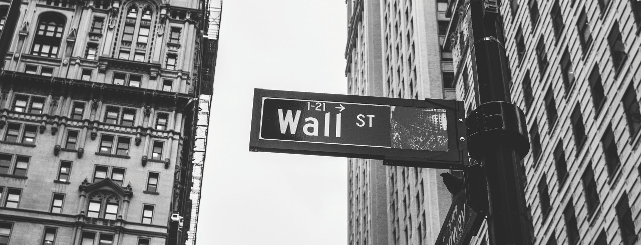 Wall Street sign in New York City with buildings in background.