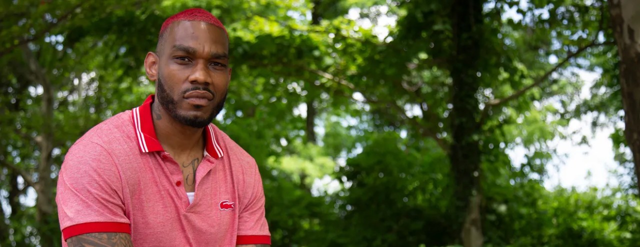 a black man with red hair wearing a red polo shirt