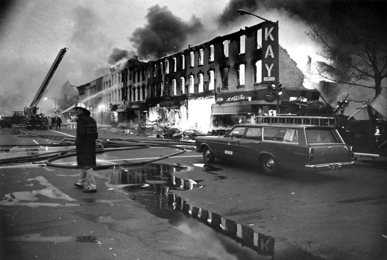 Black and white image of riot damage to buildings and fires in Washington, D.C. in 1968, after the assassination of MLK