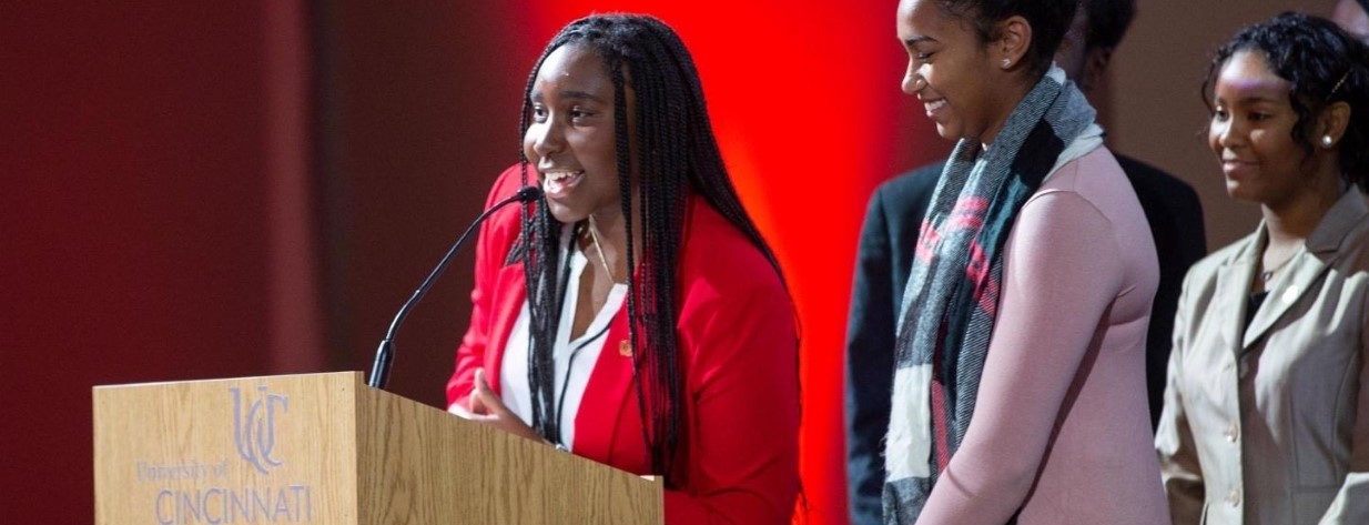 Janice Rotich delivers a speech onstage at a Darwin T. Turner scholar ceremony..