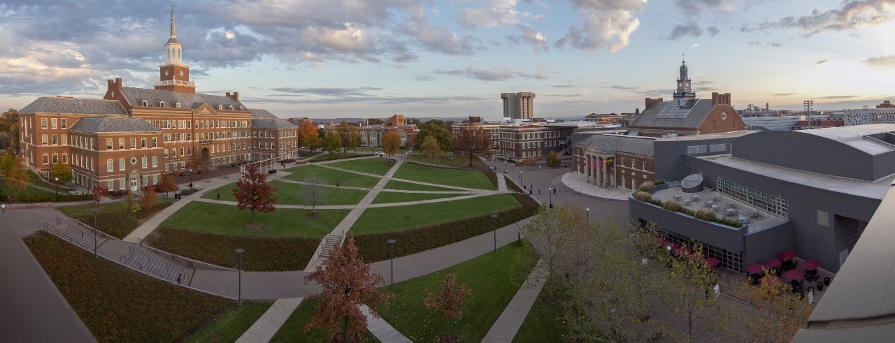 wide angle view of the uc campus showing brick buildings and a green lawn
