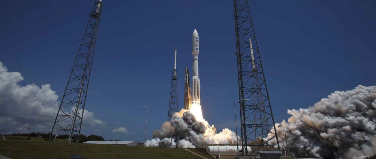 An Atlas rocket takes off from a launch pad.