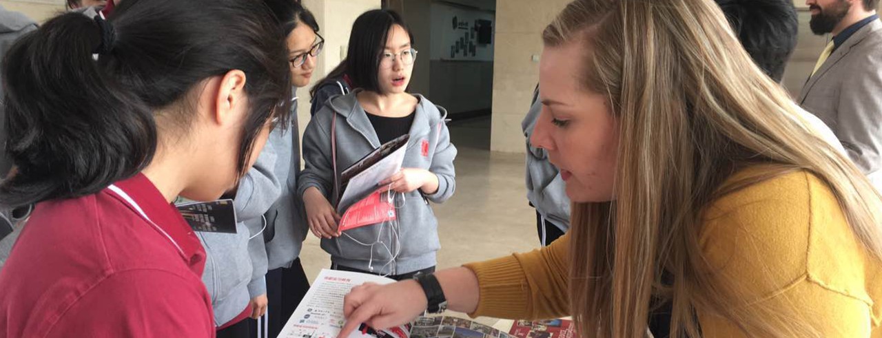 Sarah Shepherd shows a Chinese student a University of Cincinnati brochure