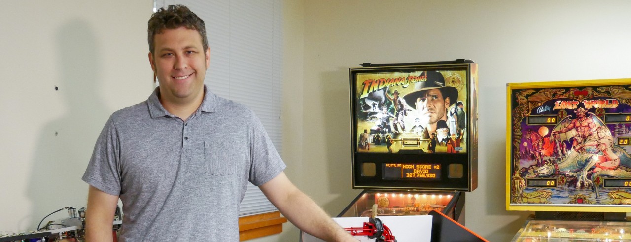 Zach Fuchs poses in his lab near pinball machines