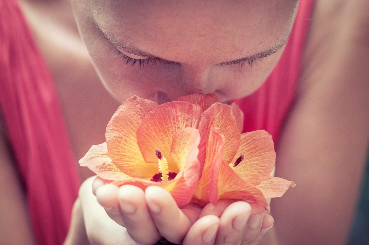 women smelling a flower