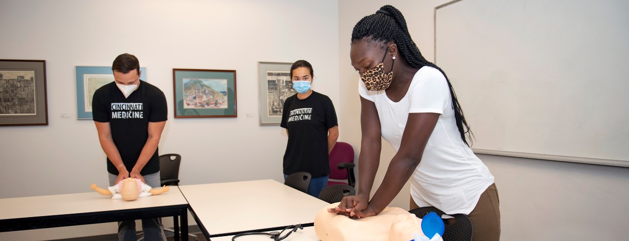 Esther Iyanobor, first year medical student, in CPR training. Jack Saczawa and Nina Bredemeier working in the background.