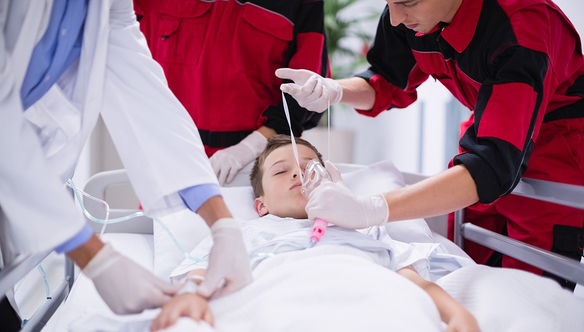 doctors adjust an oxygen mask on a child