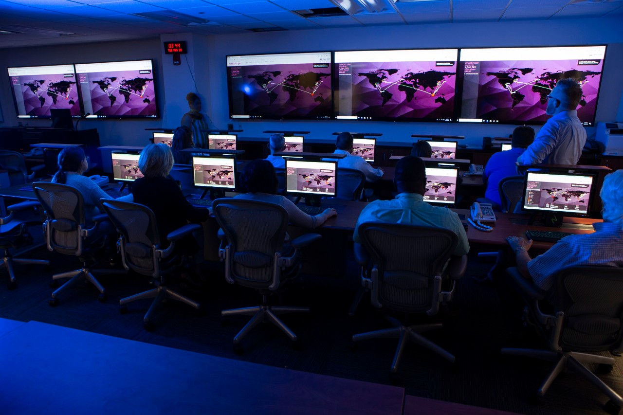 A darkened room illuminated by computer monitors