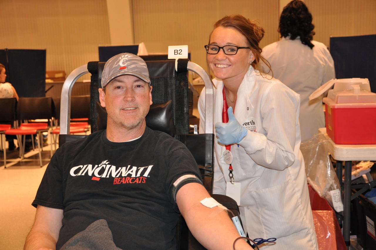 Donor in a UC Bearcats t-shirt with Hoxworth phlebotomist