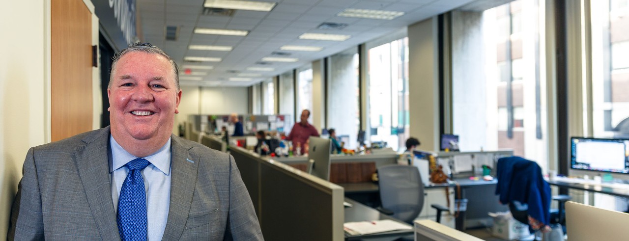 Jamie Smith, Publisher of the Business Courier, posing in suit and tie at his office.