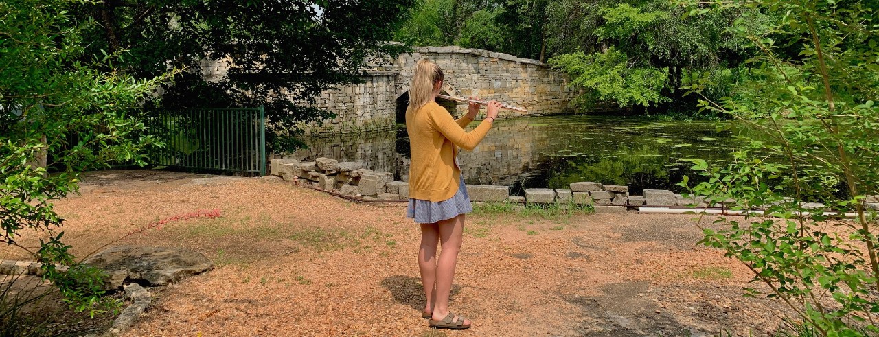 Katie Riley performs on her flute outside