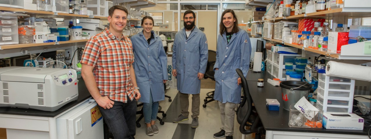 UC biologist Joshua Benoit with his students in his biology lab.