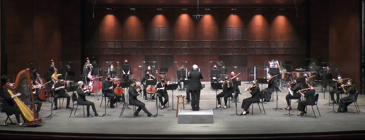 A photograph of the CCM Philharmonia performing on the stage of Corbett Auditorium.