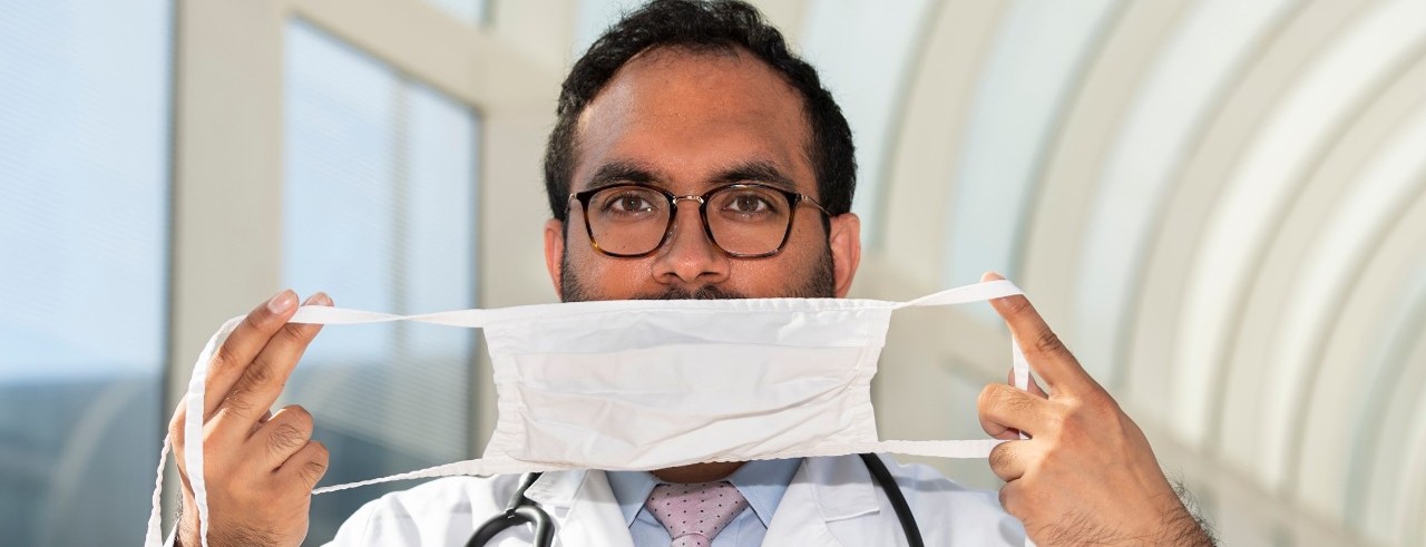Yashu Dhamija, MD, hold a face mask