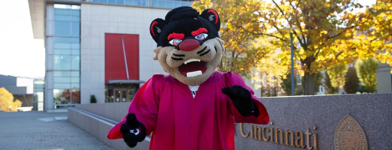 The UC Bearcat stands in front of the University of Cincinnati fountain.