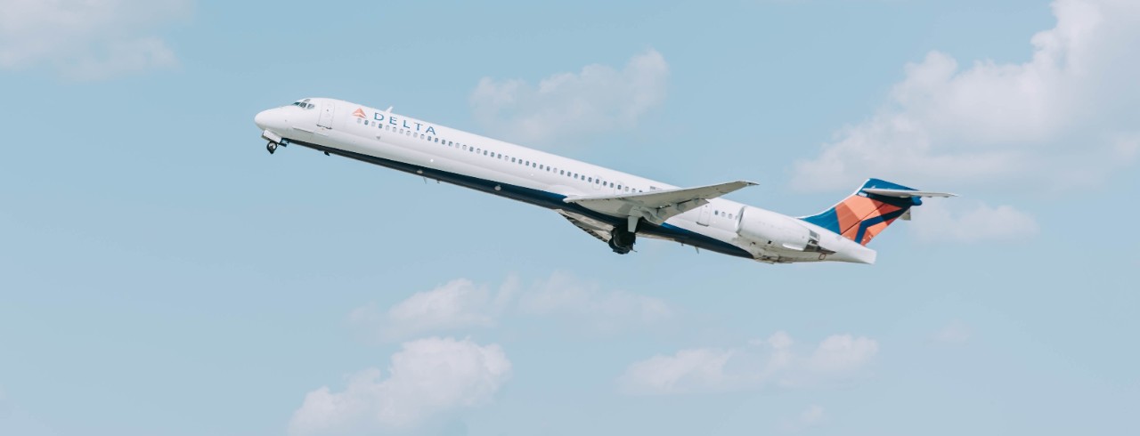 A commercial airliner flies over an airport