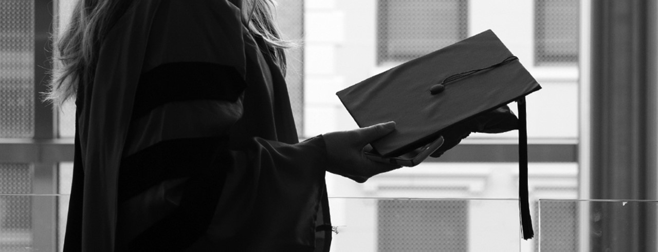woman holds graduation cap