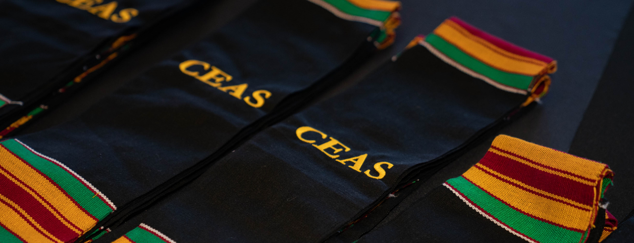 Black stoles with gold, green and dark red stripes, with "CEAS" embroidered on the center