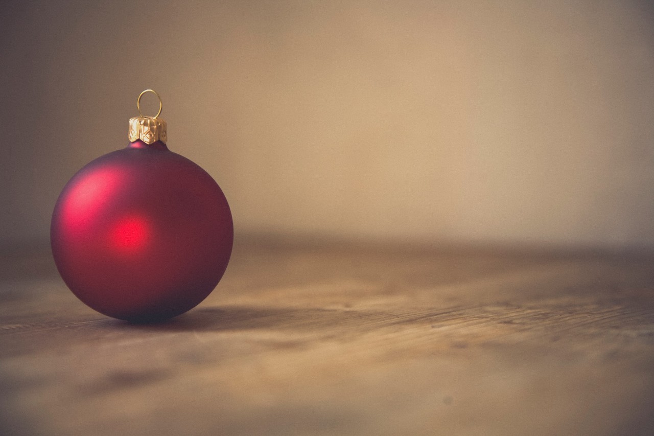 single Christmas ornament alone on a table to represent isolation 