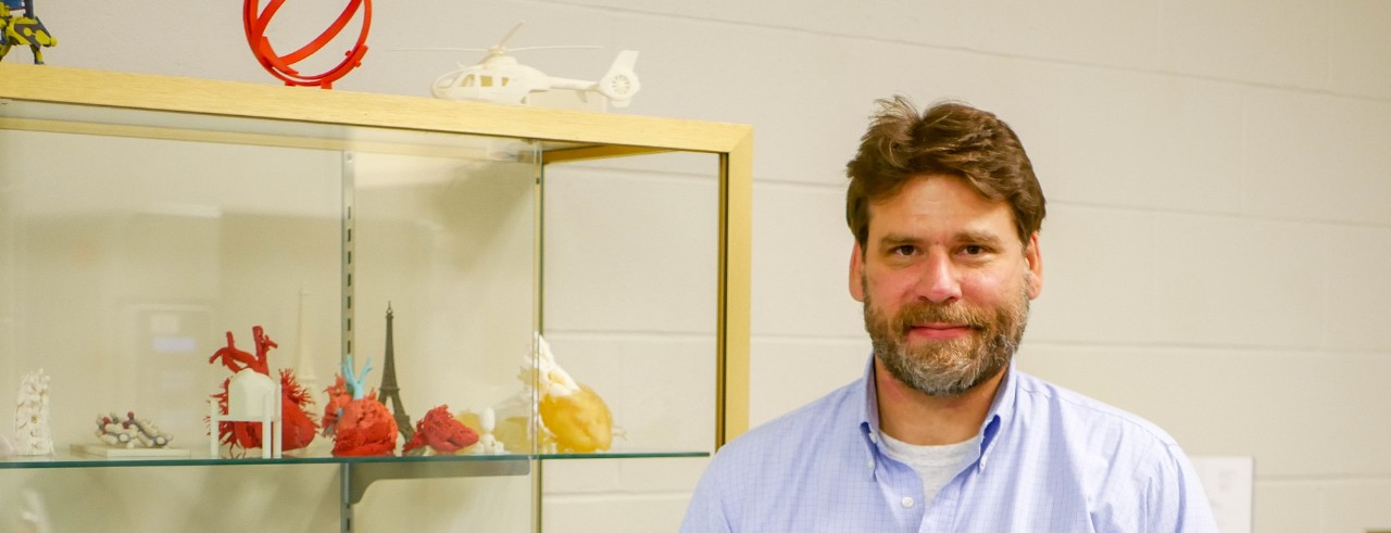 Sam Antoline with 3D-printed items from his lab