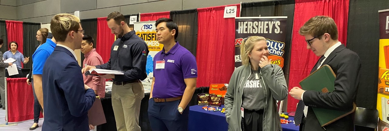 recruiters lined up to speak with students at a career fair