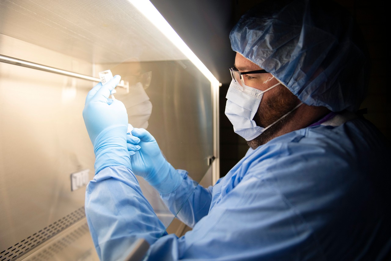 A pharmacy technician prepares a dose for a vaccine trial 