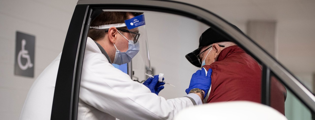 Pharmacy student Kyle Schuchter giving vaccine at drive thru 