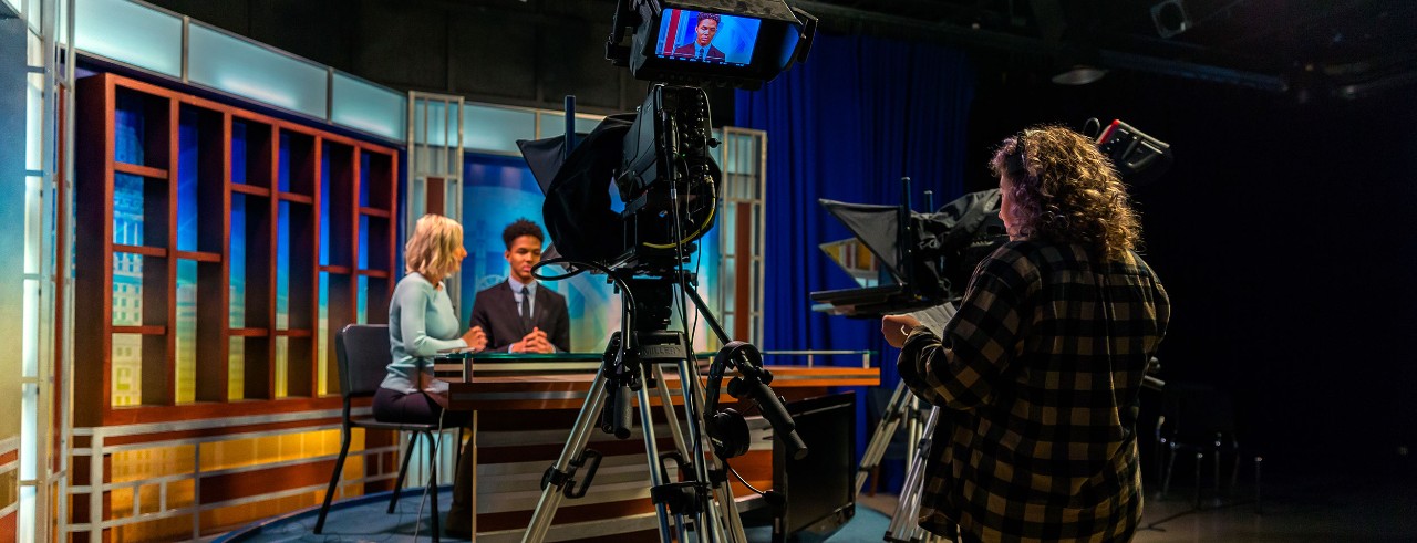 Students working in a news room studio