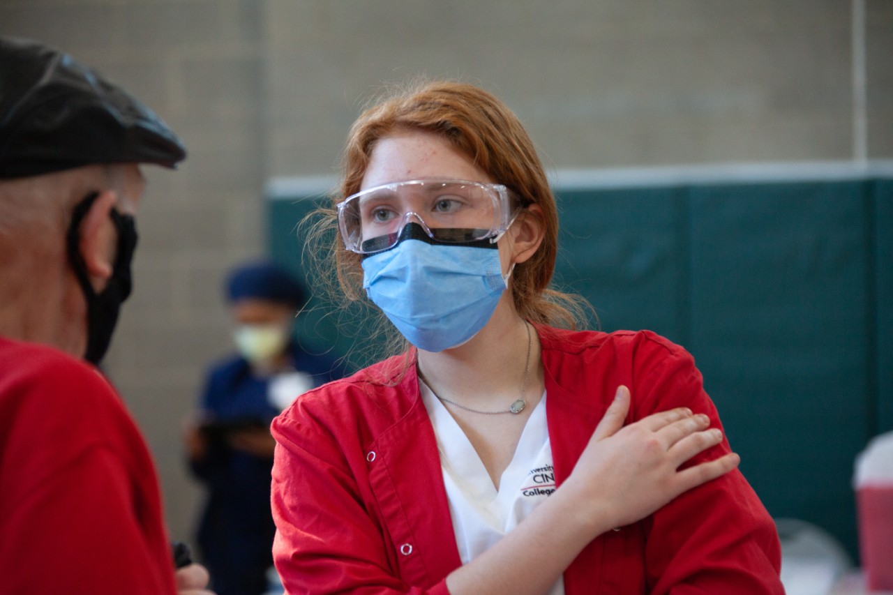 a nursing students consults with a patient at a COVID-19 vaccine clinic