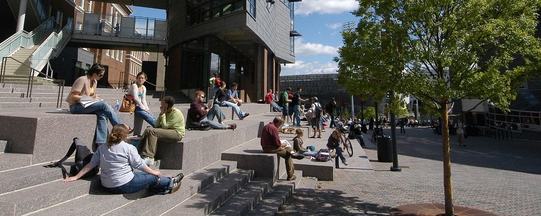 Students sitting on steps off UC MainStreet