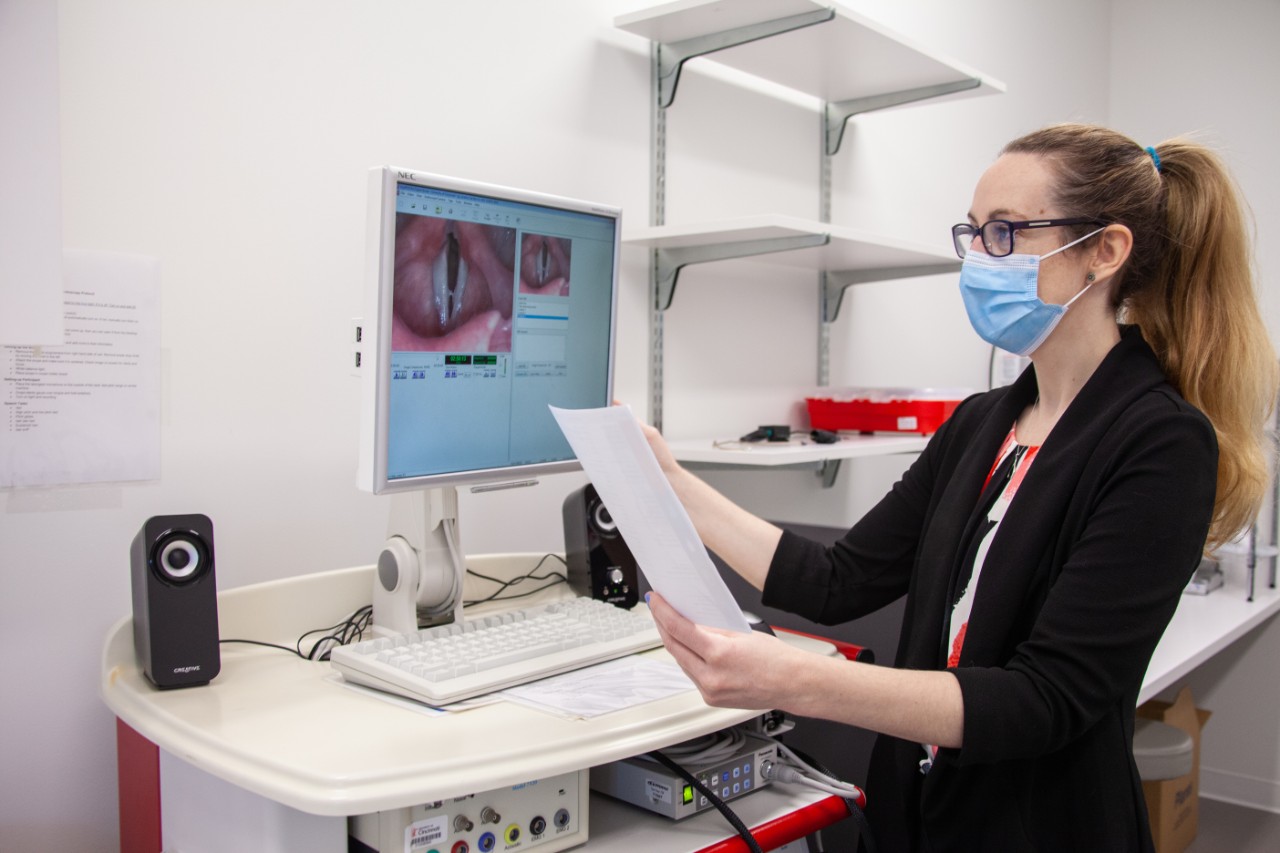 a woman in an audio lab reviewing a document