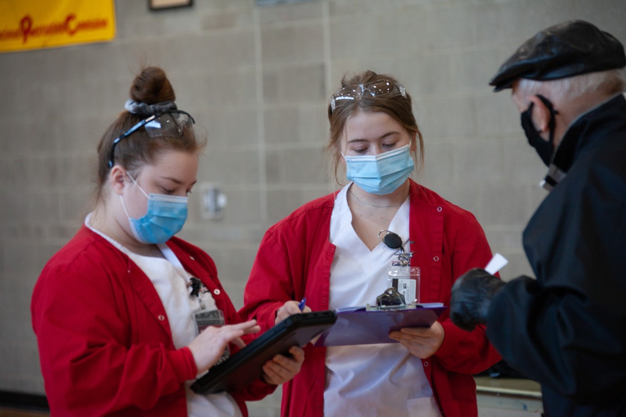 College of Nursing students help distribute COVID-19 vaccines to community members.