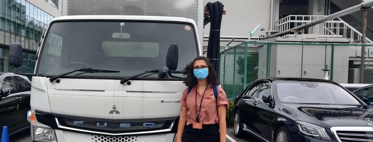 Young woman stands in front on an electric truck in Japan