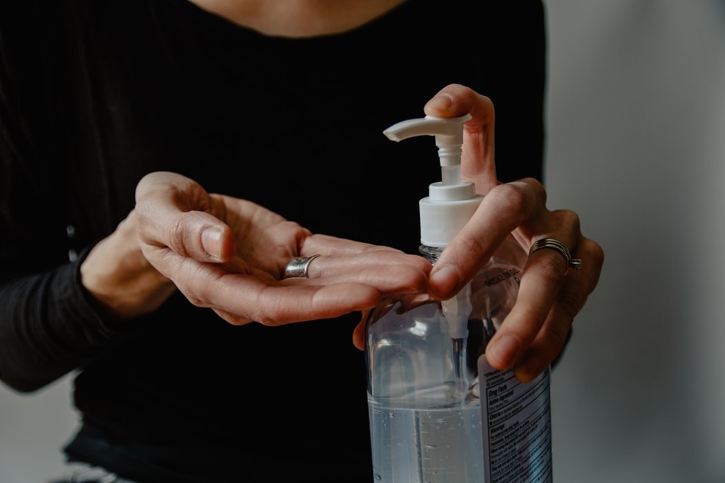 image of a person using hand sanitizer