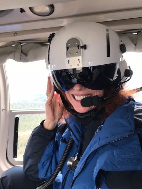 A flight nurse wearing a helmet with goggles and headset microphone