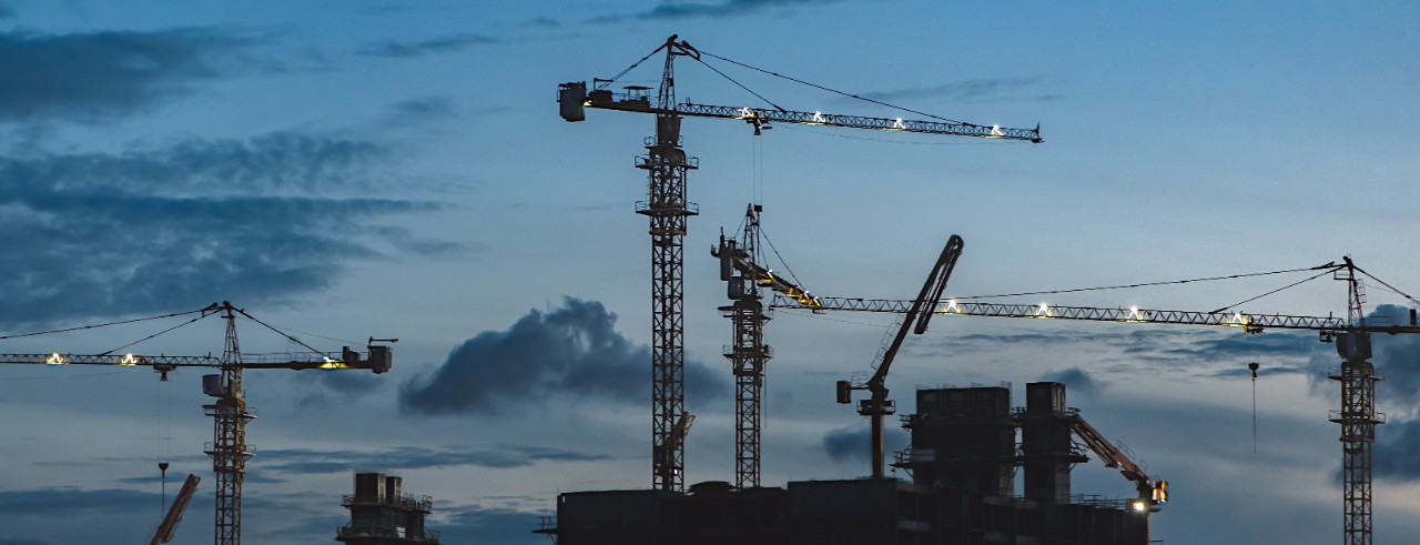 cranes at a construction site at dusk