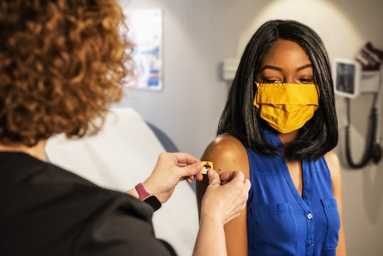 Young black woman receiving a vaccination.