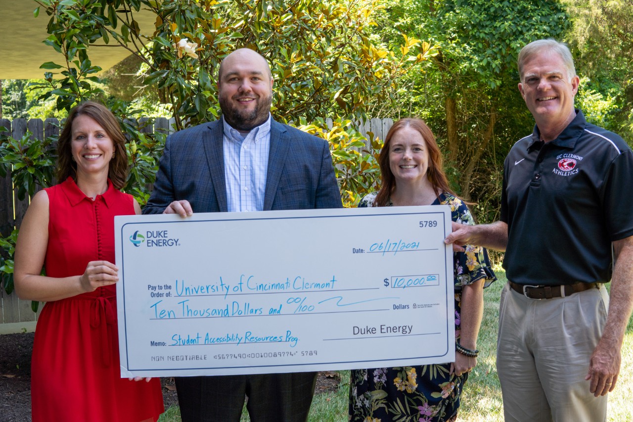 UC Clermont administrators and Duke representative posing with big check