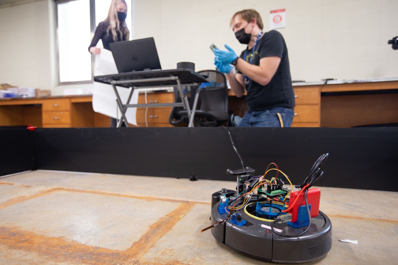 Dieter Vanderelst stands next to a robot that uses sound to navigate.