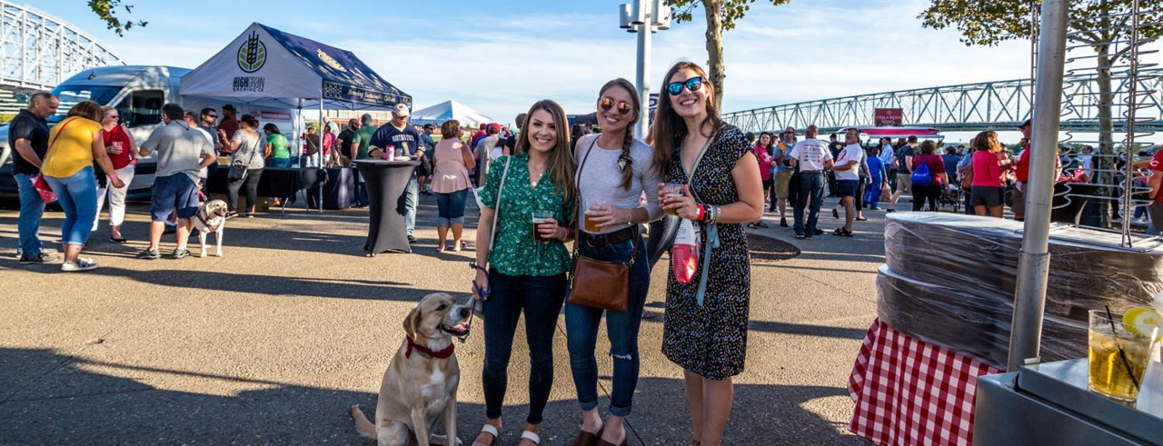 three young women and dog at outside event