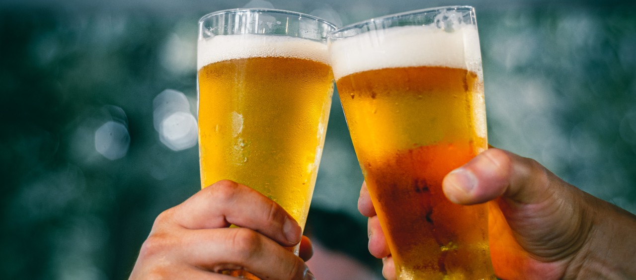Close up of hands holding pints of beer