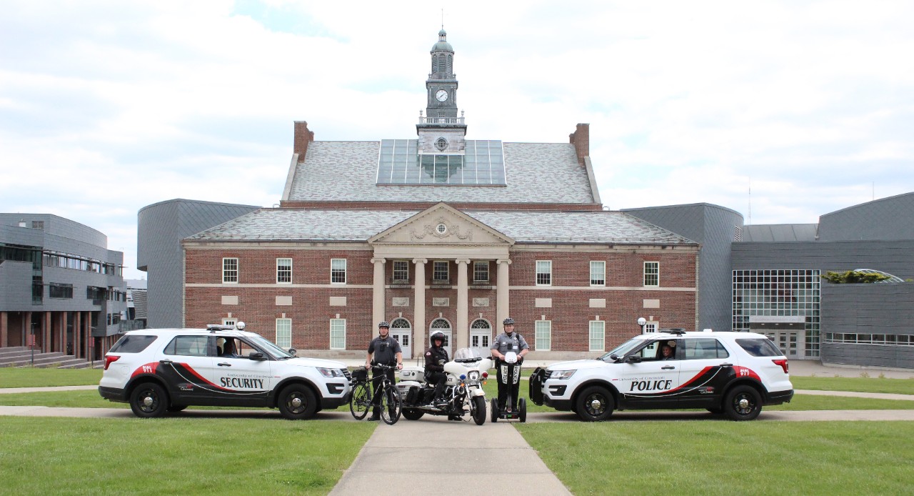 UCPD cruisers sit in front of TUC with a bicycle, segway and motorcycle.