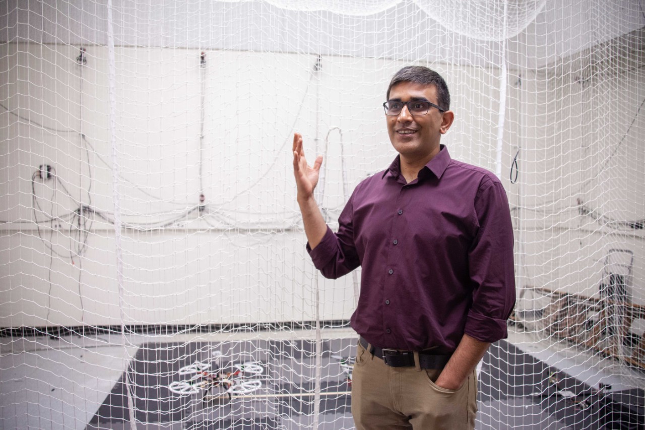 Manish Kumar gestures in front of room surrounded by netting.