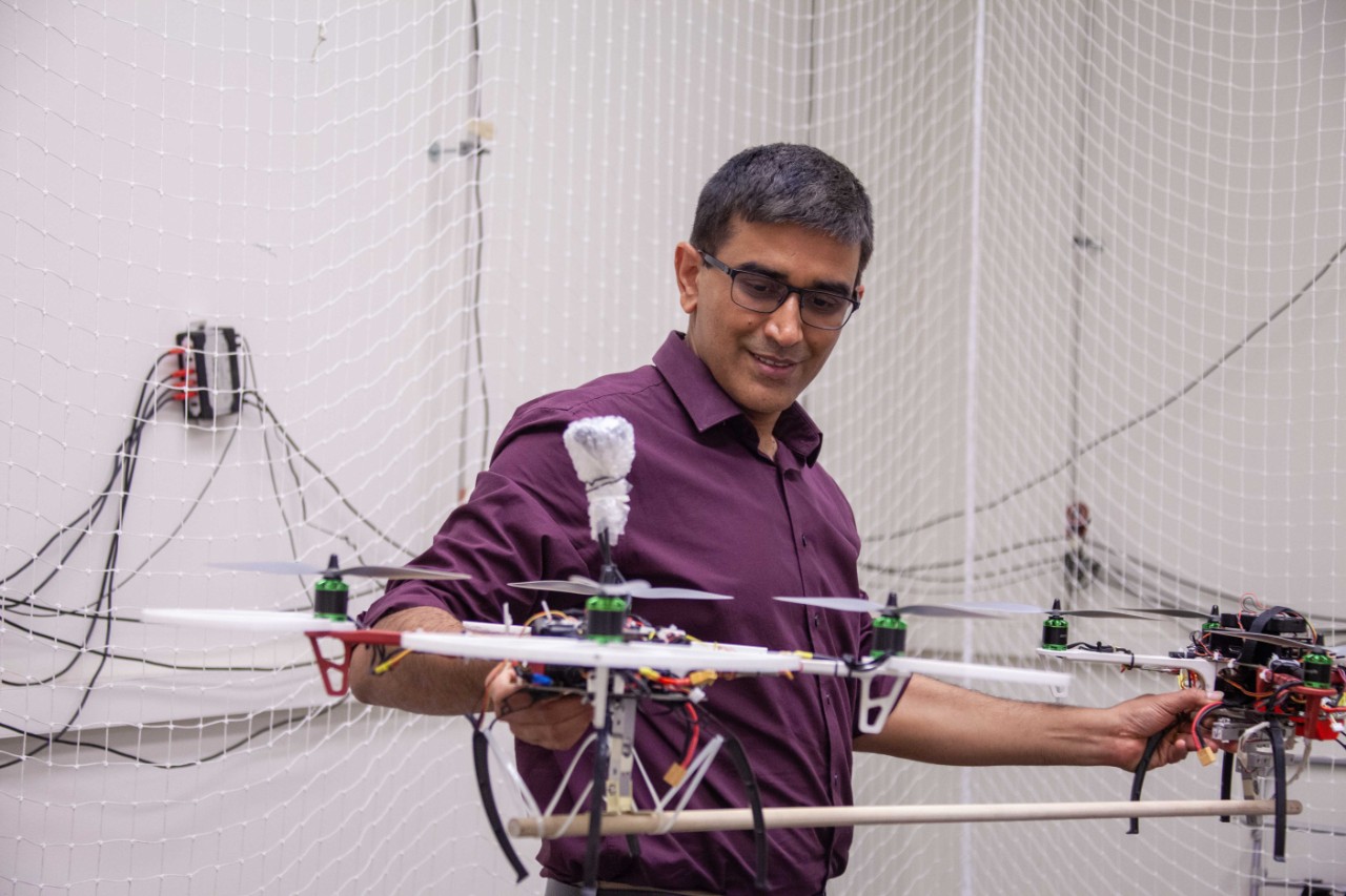 Manish Kumar holds two drones connected with a rod.