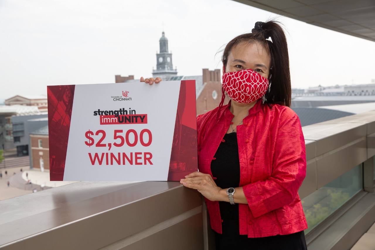 Woman holds sign indicating winning $2500