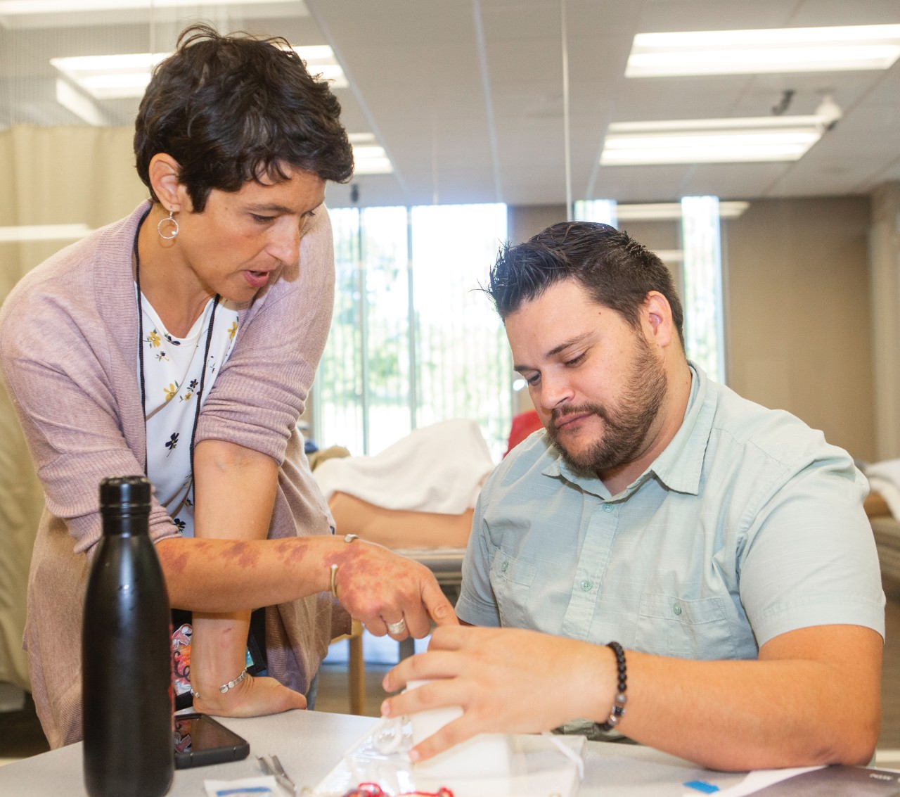 Man receiving hand care from a nurse