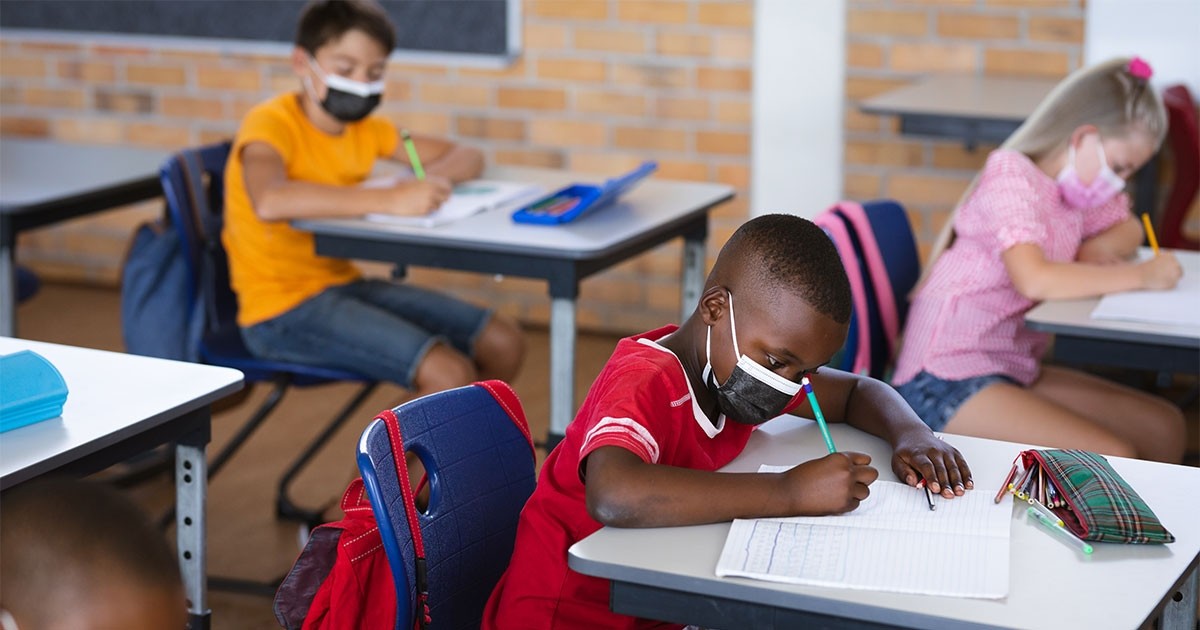 students in class wearing masks while seated at their desks