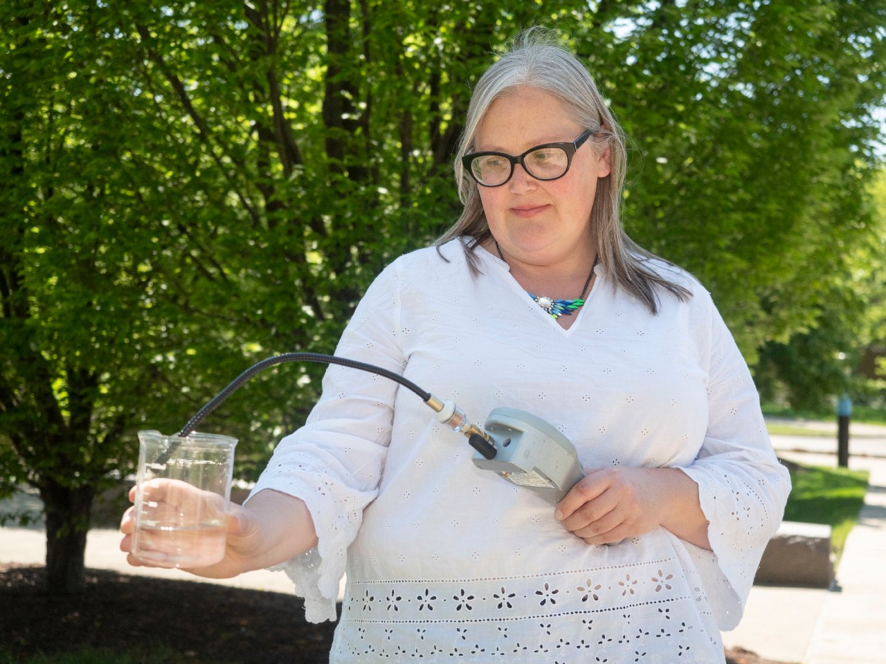 UC associate professor Amy Townsend-Small samples methane in a beaker of water.