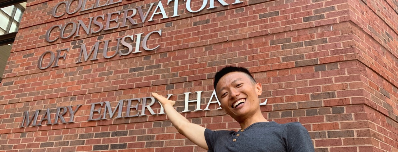 University of Cincinnati doctoral student Wenbo Yin stands outside Mary Emery Hall at the College-Conservatory of Music