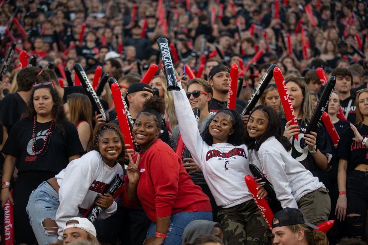 Four women show school spirit amidst a crowd of UC supporters.